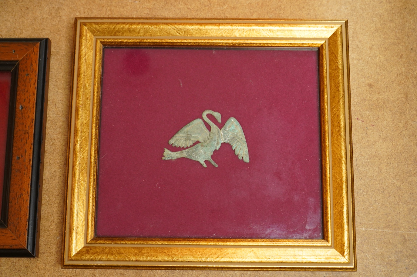 A Roman bronze badge, a medieval pewter badge and silver badges in the form of Sardinia emblems all framed., Swan badge 6cm wide, not including mount or frame. (Requires provenance)